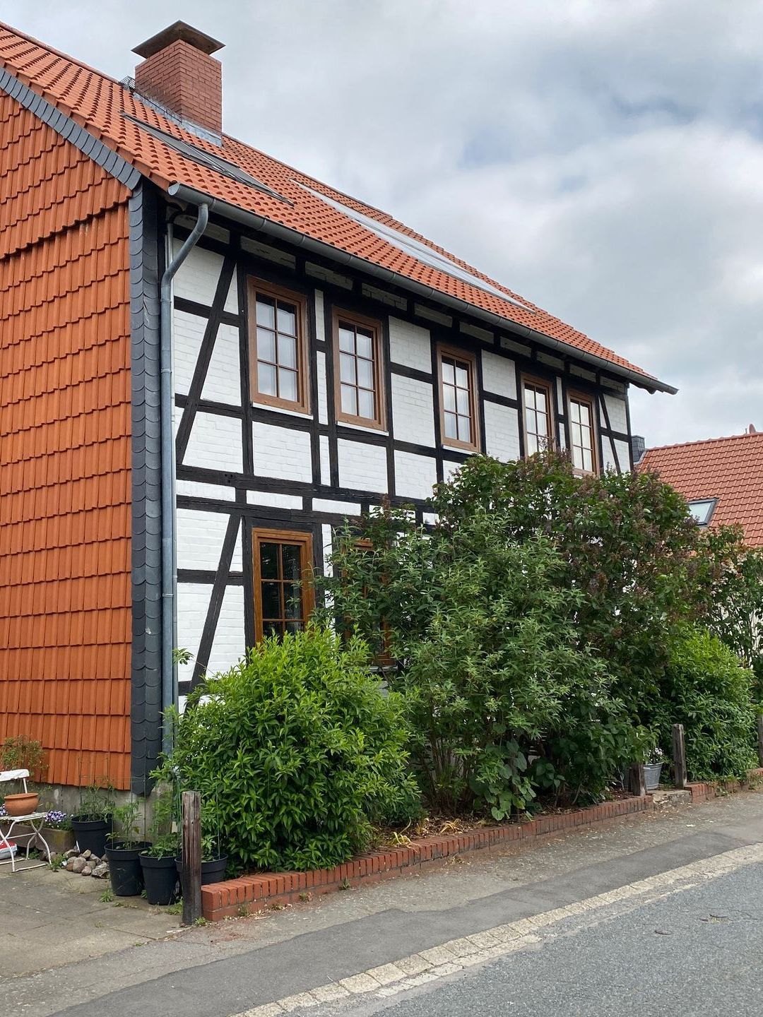 Am Straßenrand steht ein Haus mit einem roten Ziegeldach.