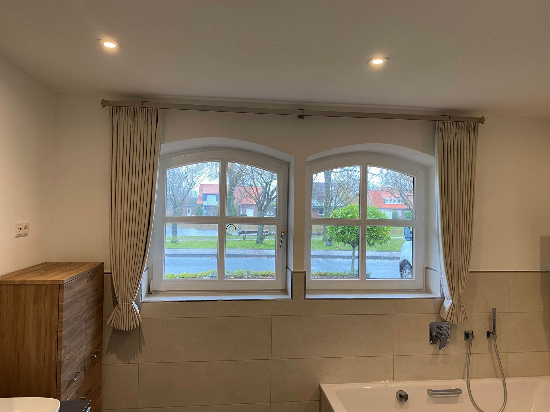 Ein Badezimmer mit zwei Fenstern und einer Badewanne.