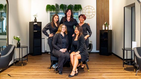 Eine Gruppe von Frauen posiert in einem Friseursalon für ein Foto.