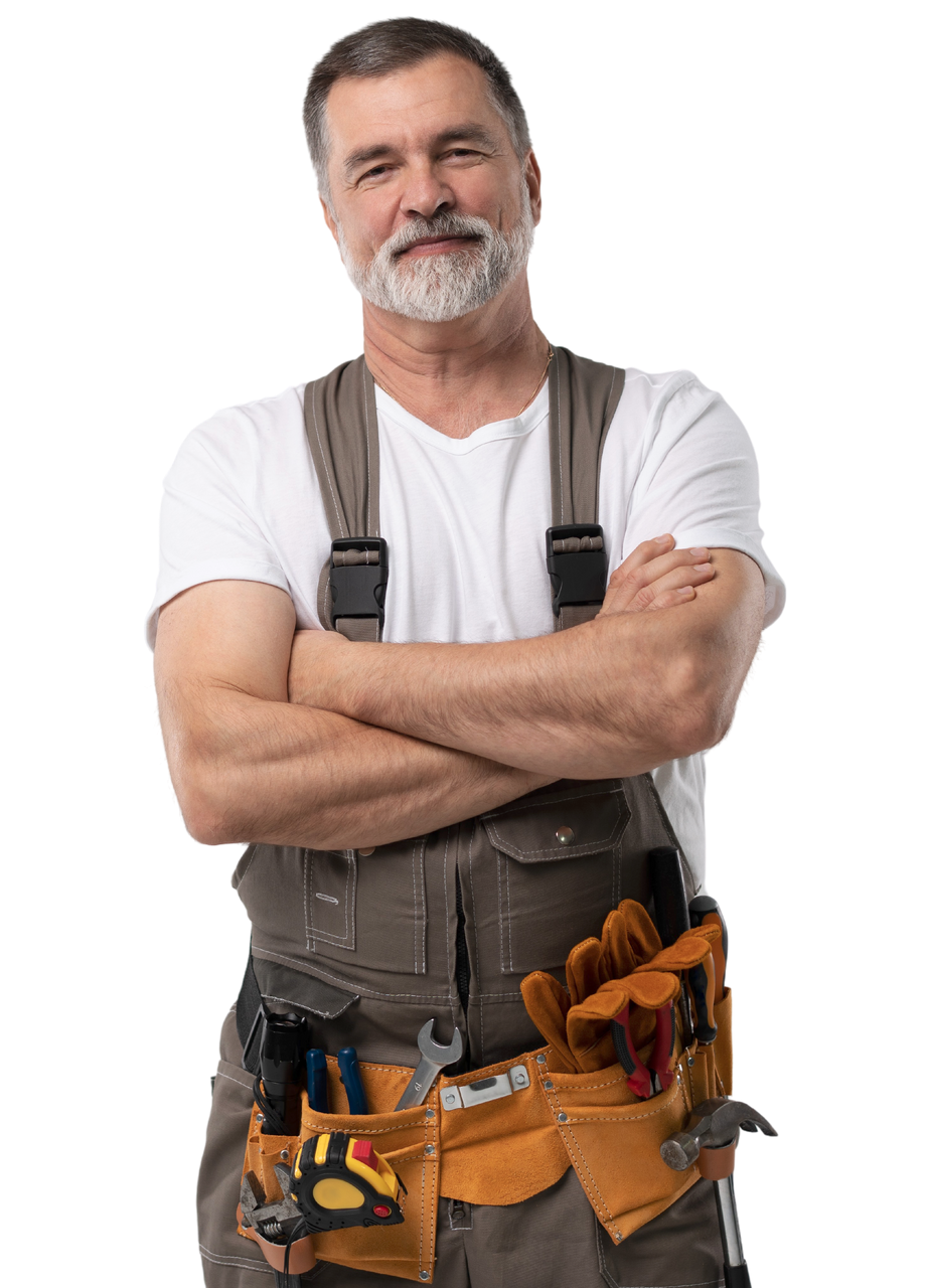 Un ouvrier du bâtiment, les bras croisés, portant une salopette et une ceinture à outils, sourit à la caméra.