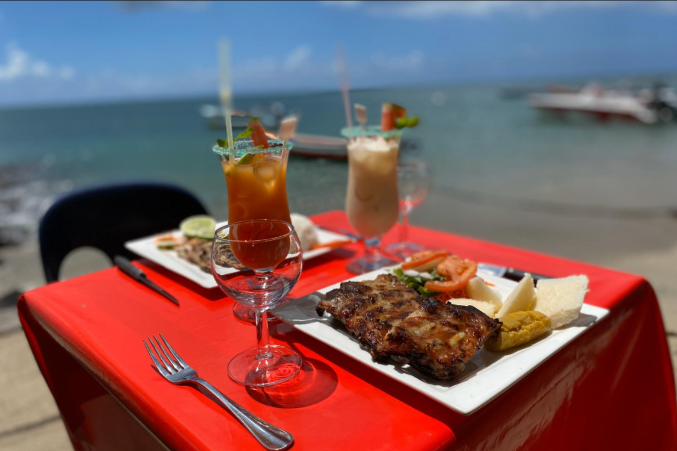 Table avec nourriture et boissons, nappe rouge, fond océan.