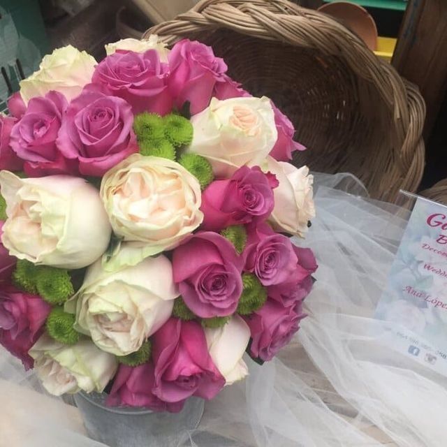 Ramo de rosas rosas, blancas y color crema con toques verdes, envuelto en tul blanco