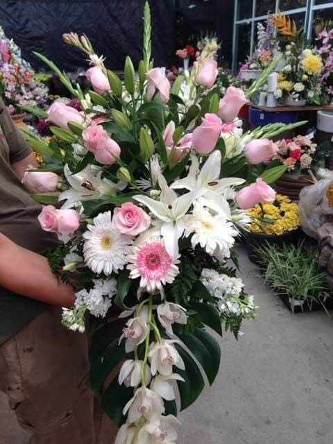 Ramo de flores rosas y blancas con lirios y margaritas en un mercado de flores al aire libre
