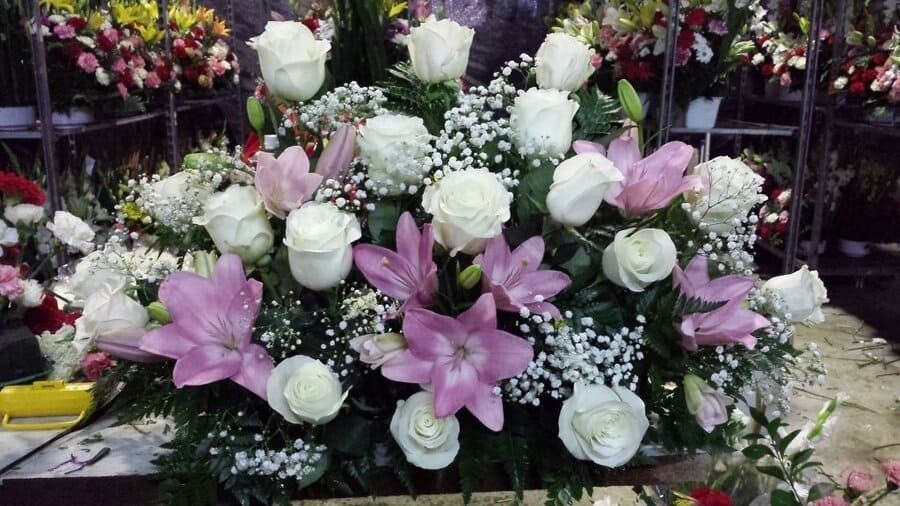 Ramo floral rosa y blanco con lirios y rosas en una exhibición de tienda