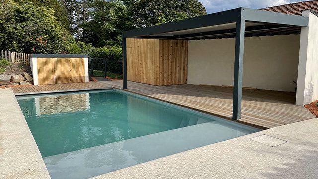 Superbe terrasse avec piscine creusée et pergola en acier noir