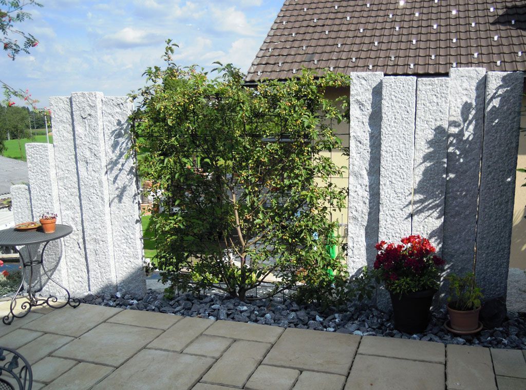 Sichtschutz mit Pflanzen und Natursteinstellen kombiniert - Hadorn Gartenbau