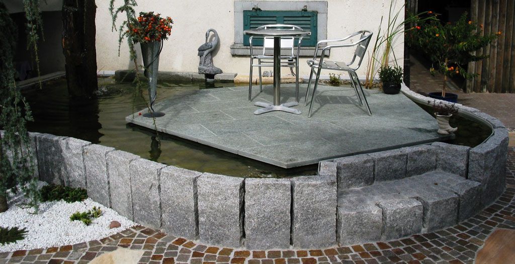Sitzplatz in Teich mit Granitstellen eingefasst - Hadorn Gartenbau