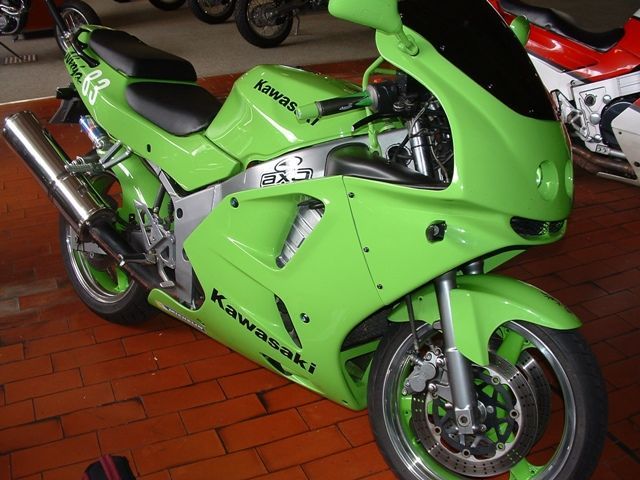 Ein grünes Kawasaki-Motorrad steht auf einem Ziegelboden