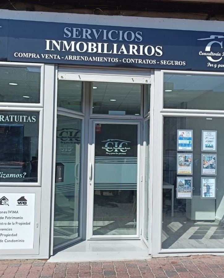 Un escaparate con un cartel que dice servicios inmobiliarios