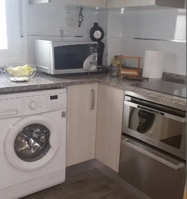 Una cocina con lavadora, microondas y horno