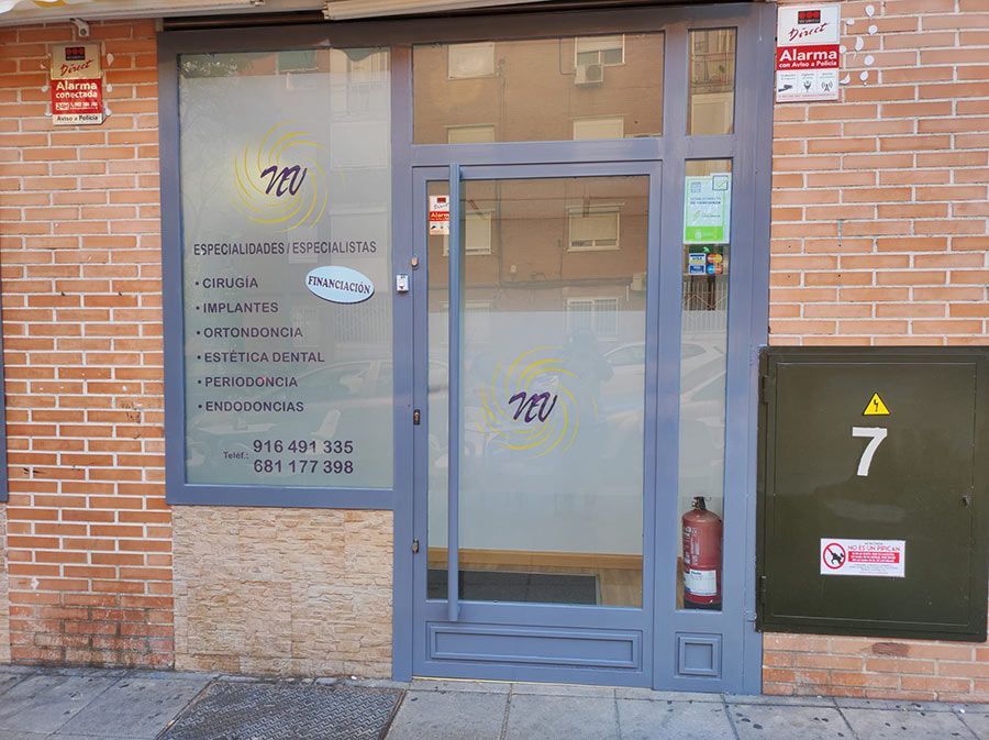 Local comercial con puerta de cristal, fachada de ladrillo y caja de servicios públicos negra marcada con el número 7 junto a la entrada.
