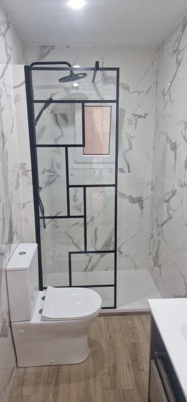 Un baño con inodoro, ducha y lavabo.