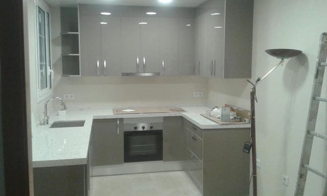 Una cocina con fregadero, estufa y lámpara.