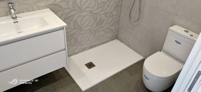 Un baño con inodoro, lavabo y ducha.