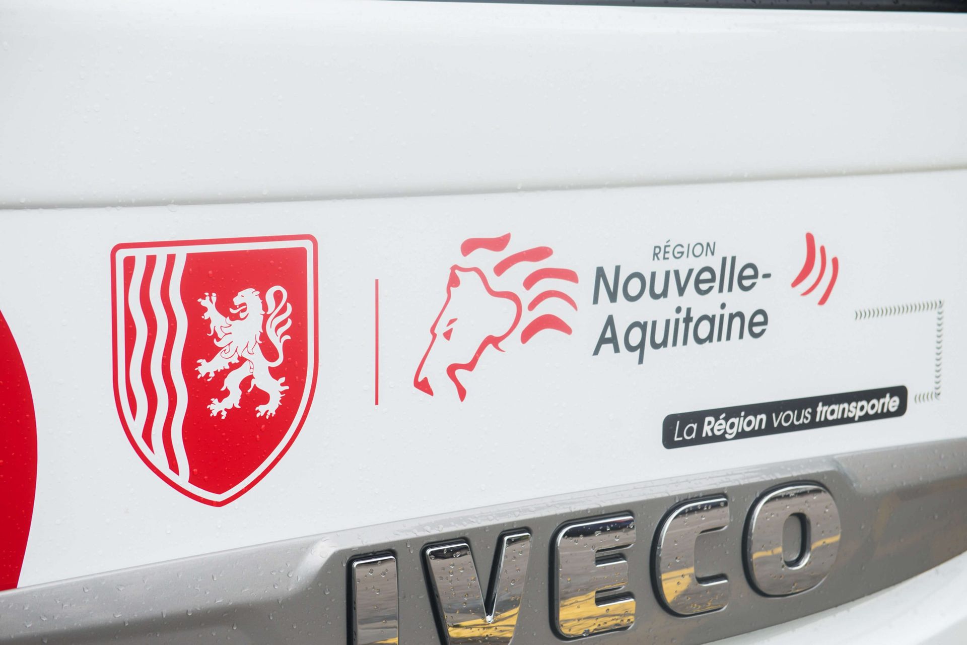 Gros plan sur un véhicule blanc arborant le logo de la Nouvelle-Aquitaine (France) en rouge. La marque « IVECO » figure en dessous.