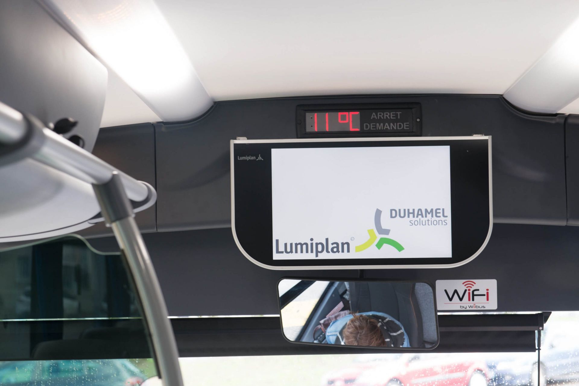 Écran d'affichage intérieur du bus montrant le logo « Luminiplan », l'heure et le symbole Wi-Fi.