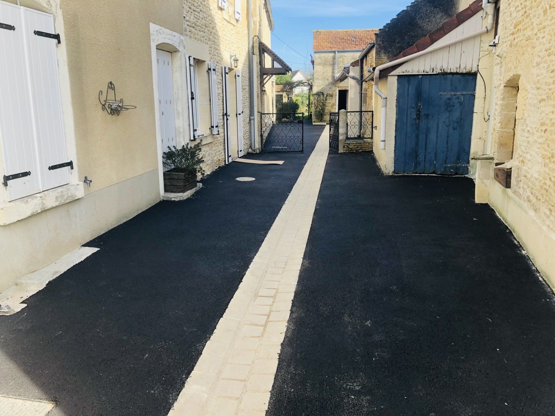 Pose d'un caniveau et d'un revêtement en enrobé