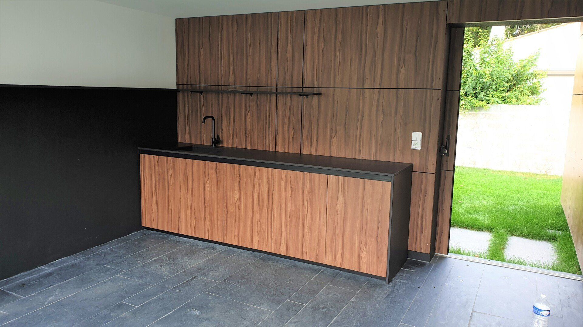 Aménagement en bois d'une belle cuisine avec un jardin en arrière-plan