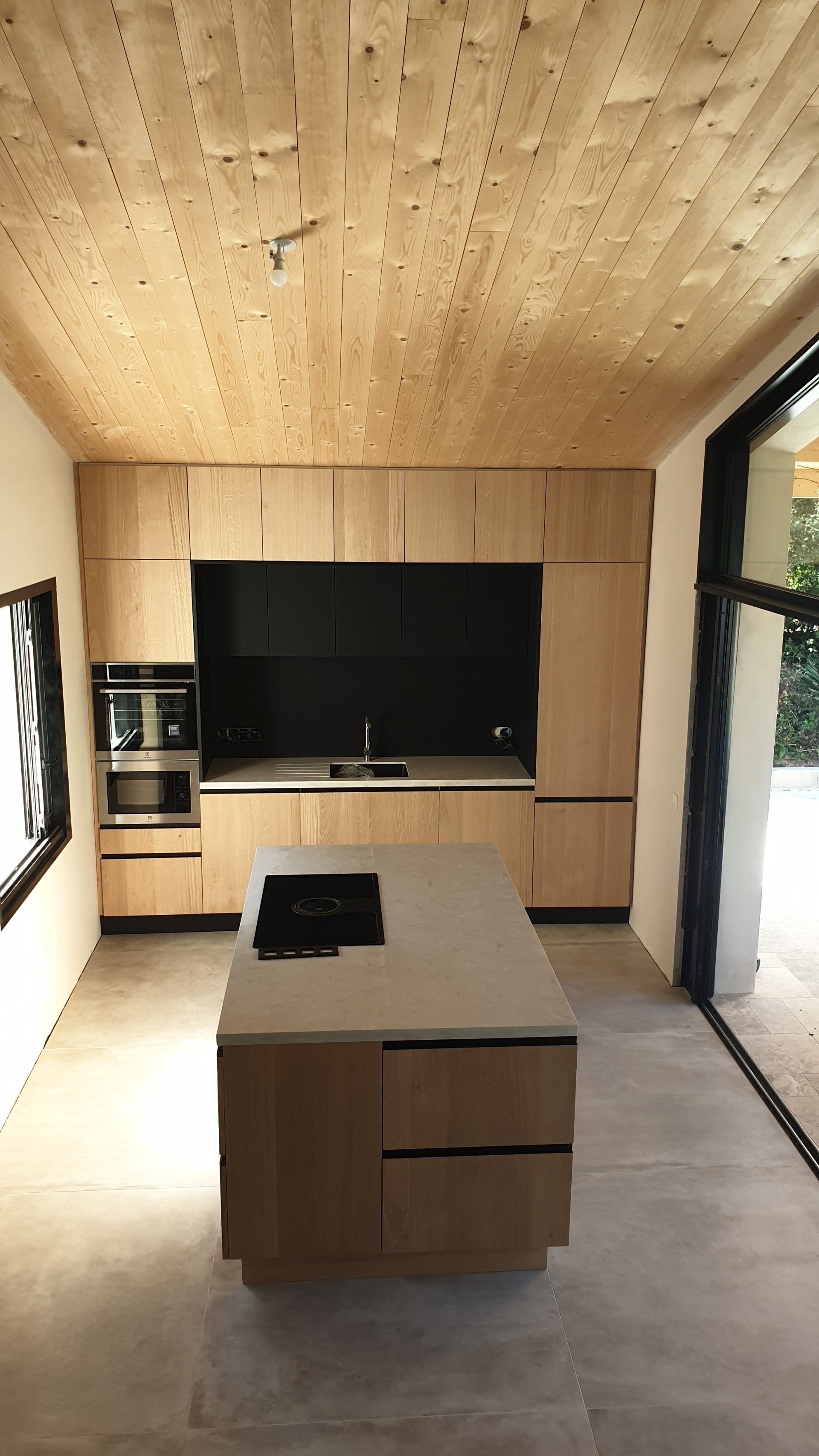 Belle cuisine en bois avec au premier plan un plan de travail et au fond un évier