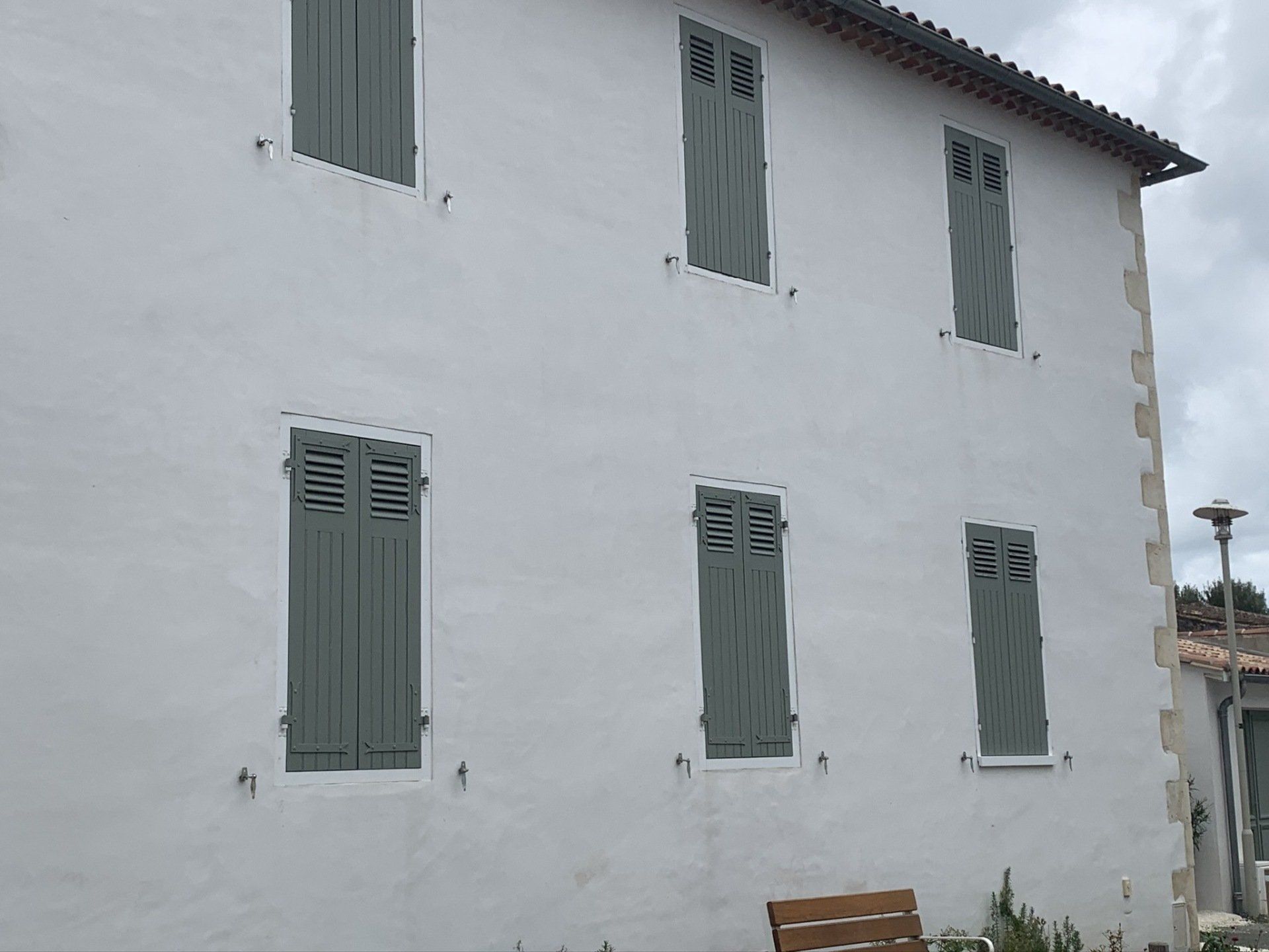 Volets battants fermés sur une grande façade blanche