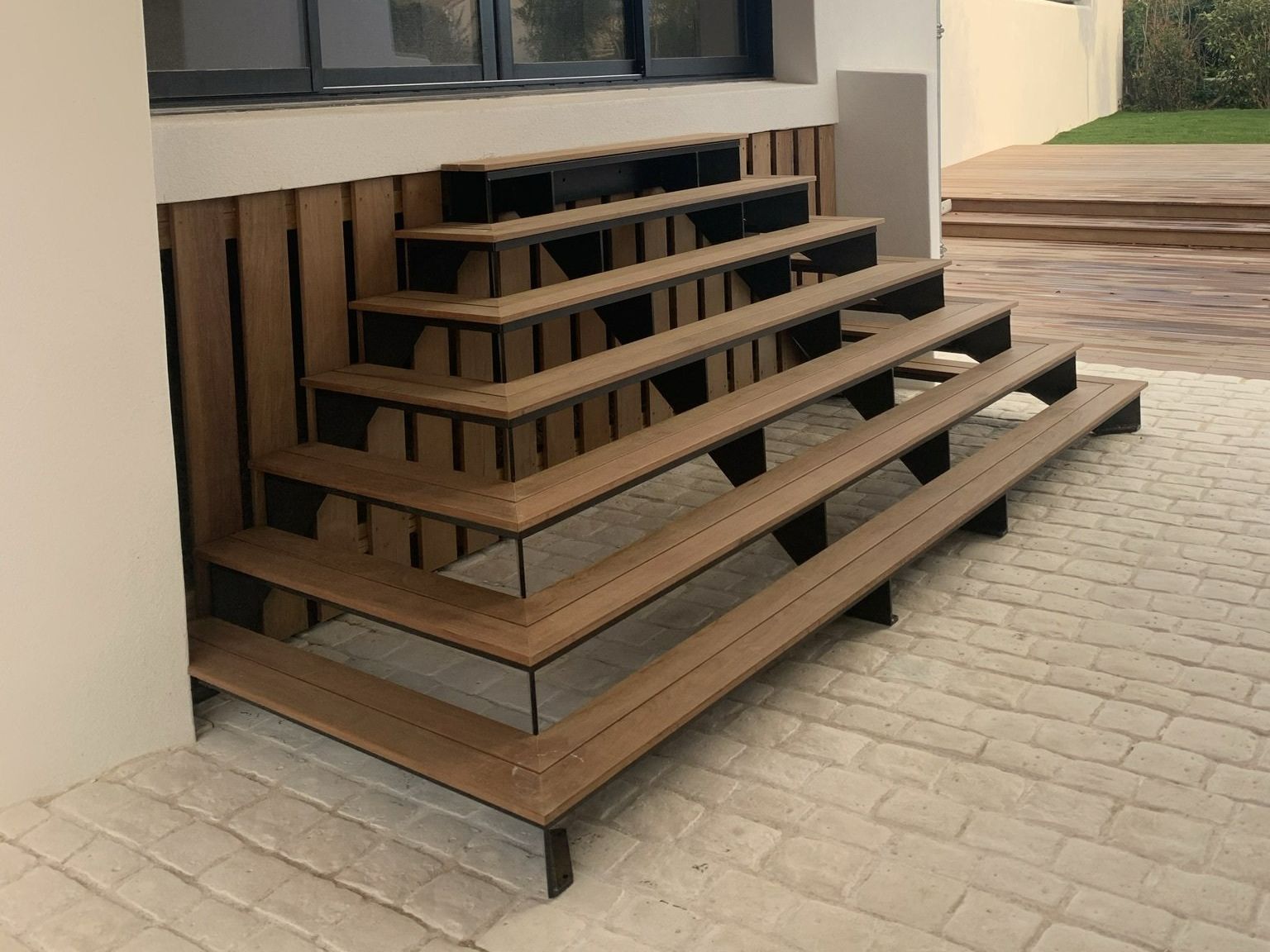 Escalier en bois extérieur devant une fenêtre