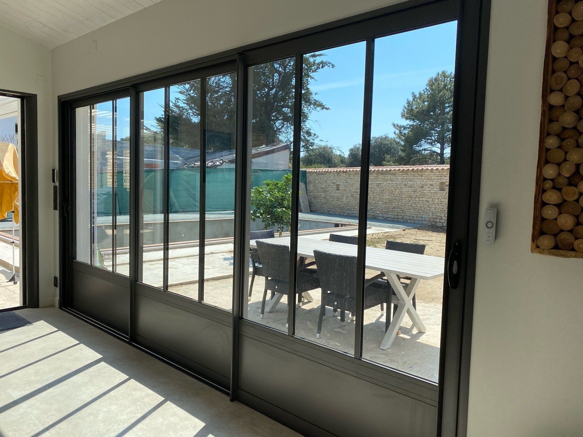 Grande baie vitrée qui donne sur une terrasse