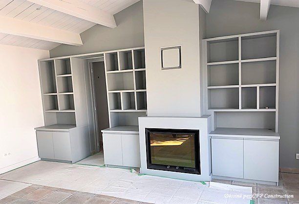 Bibliothèque blanche et vide entourant une cheminée