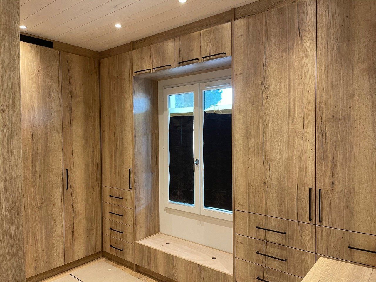 Grand dressing en bois entourant une fenêtre