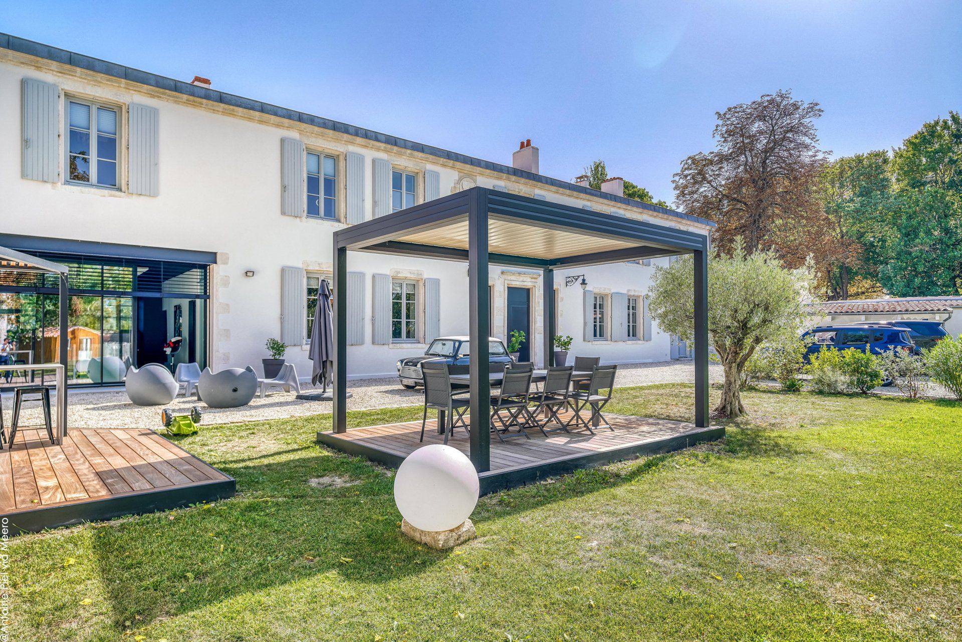 Grand jardin avec une pergola sous un ciel bleu