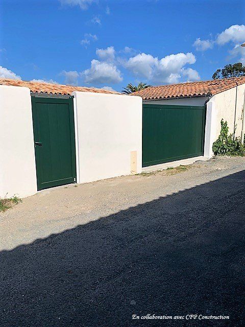 Portail et portillon sur un mur blanc