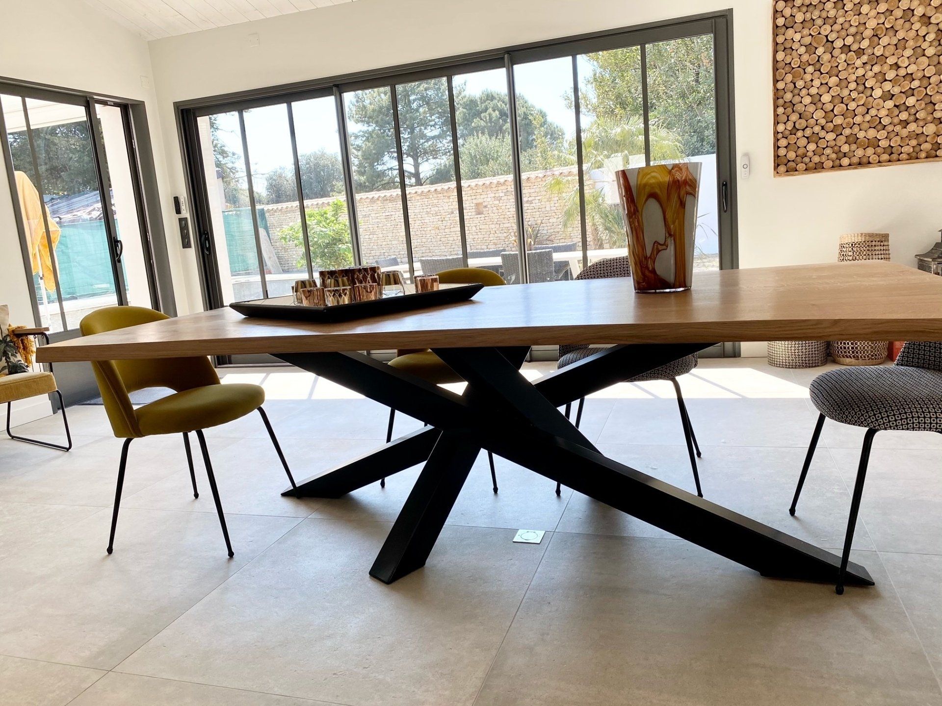 Grande table en bois devant une verrière