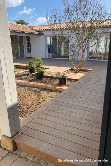 Chantier de terrasse en bois comprenant des plantes et des arbustes