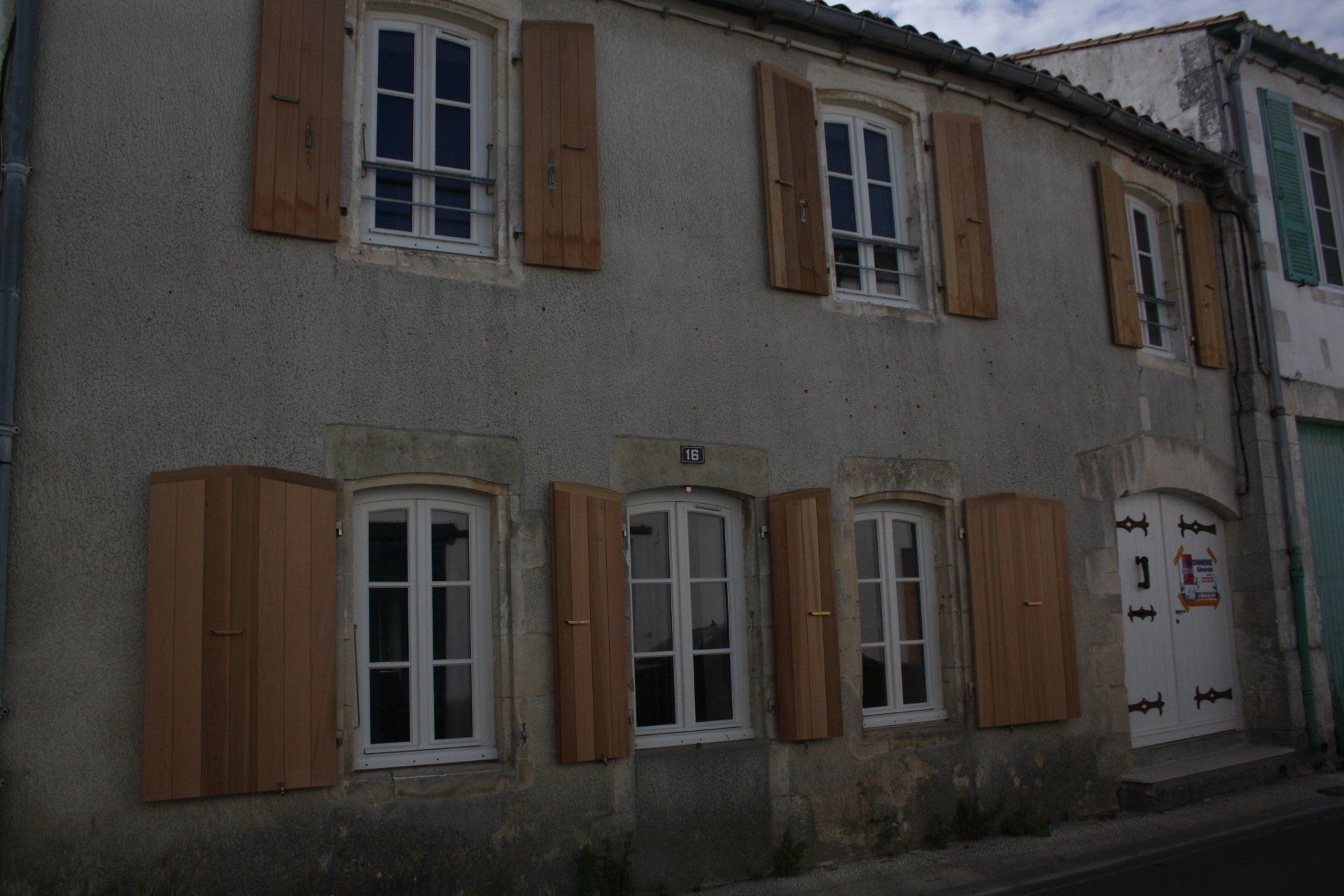 6 fenêtres et une porte avec des menuiseries traditionnelles et des volets à battants