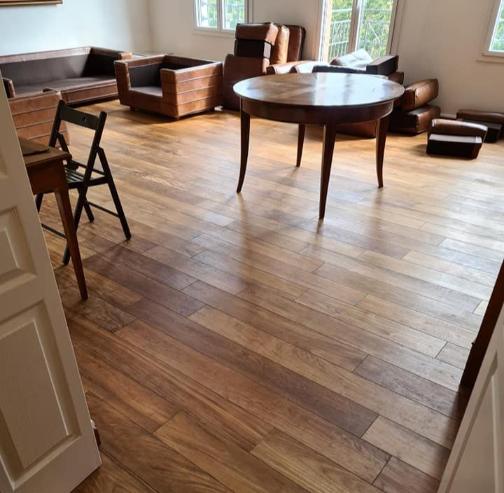 Un salon lumineux avec un parquet en bois.