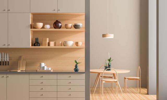 Cuisine et coin repas minimalistes beiges avec étagères en bois, table, chaises et suspension lumineuse.