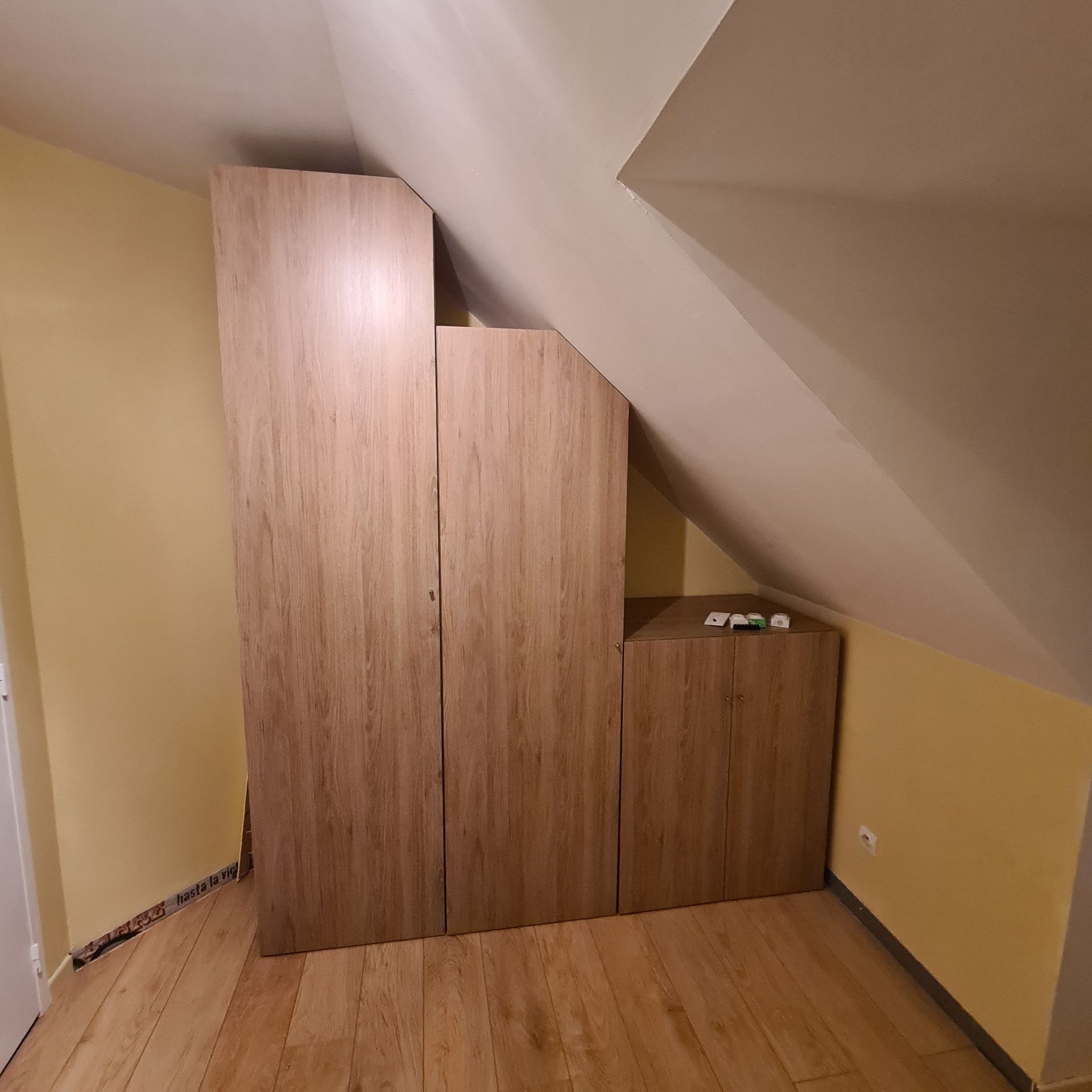 Un meuble de rangement sur mesure, sous un toit en pente.
