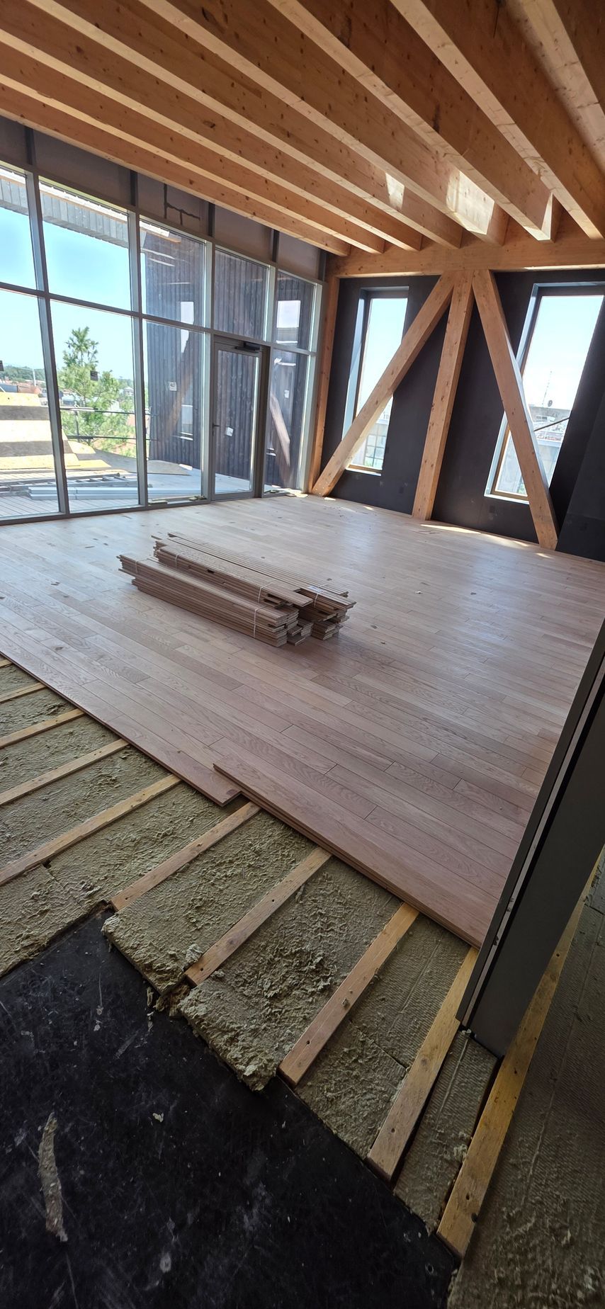 Un parquet massif en cours d'installation dans une pièce lumineuse.