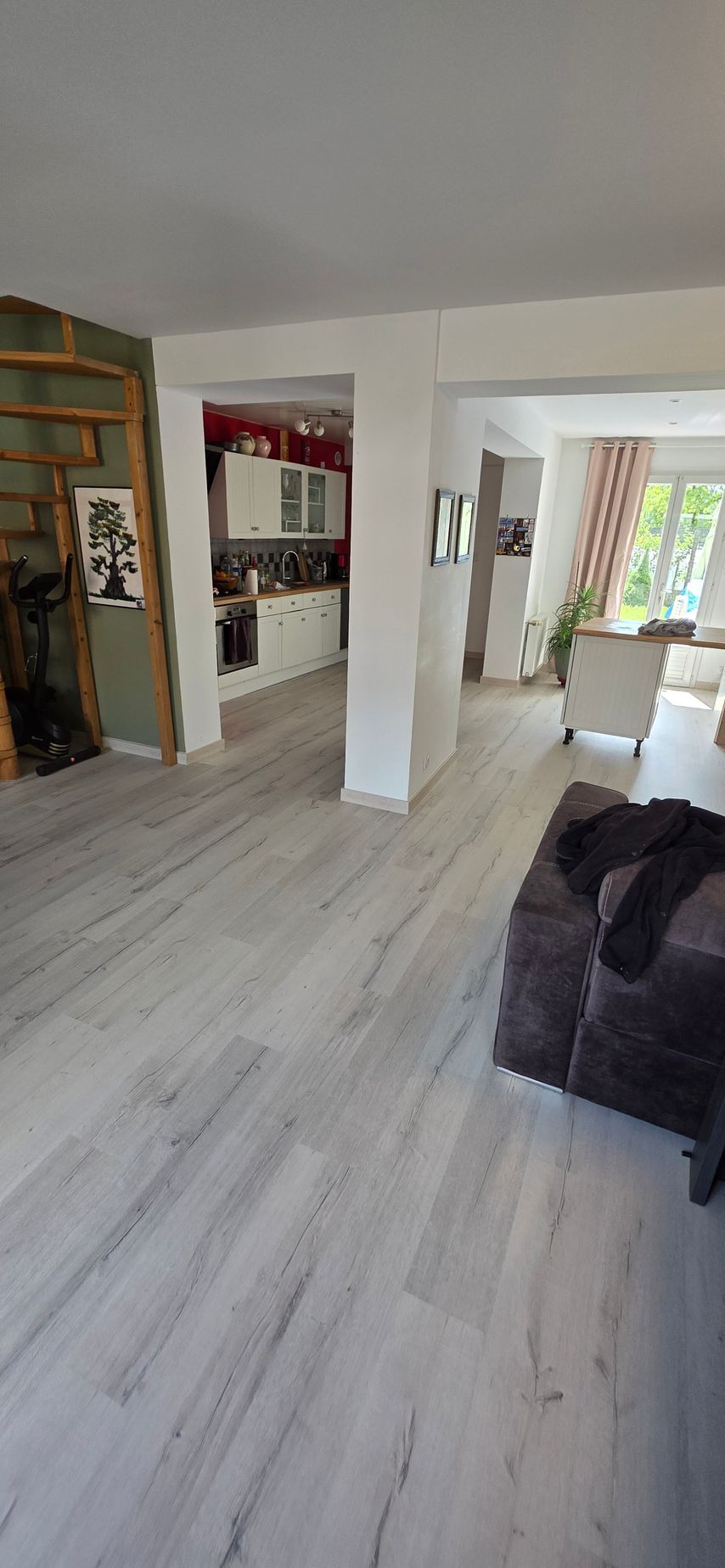 Une maison lumineuse avec un parquet blanc au sol.