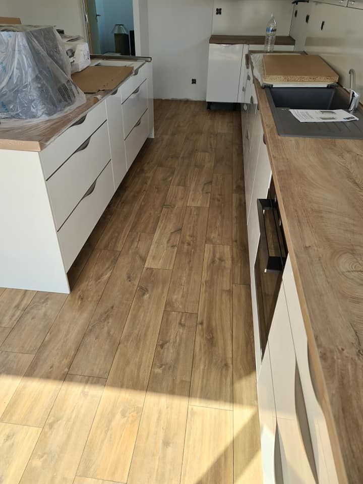 Une cuisine moderne en rénovation avec un parquet et des plans de travail en bois.
