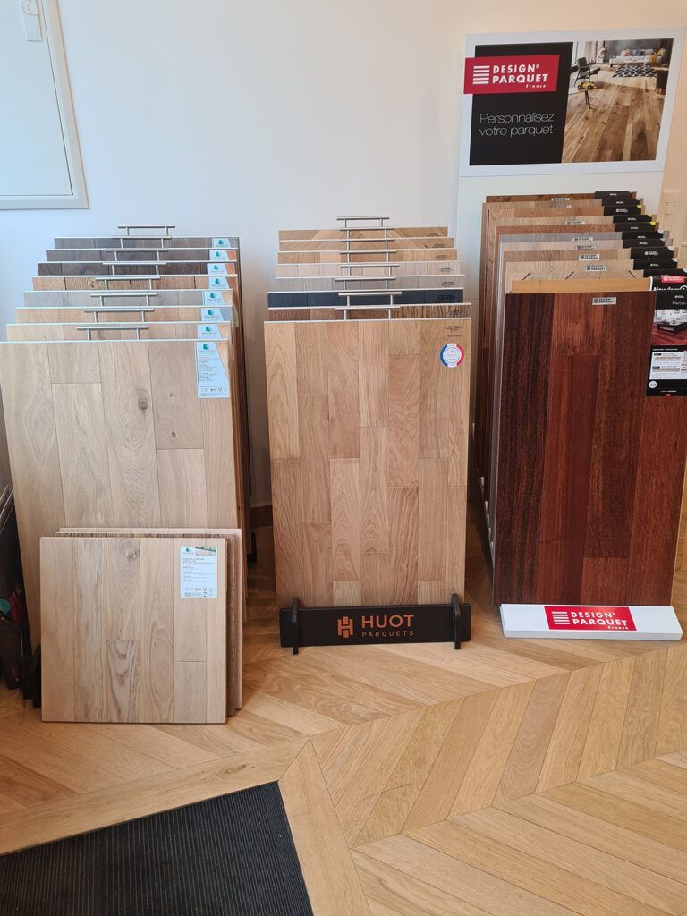 Des échantillons de parquet disposés en rangées sur le sol d'une salle d'exposition.