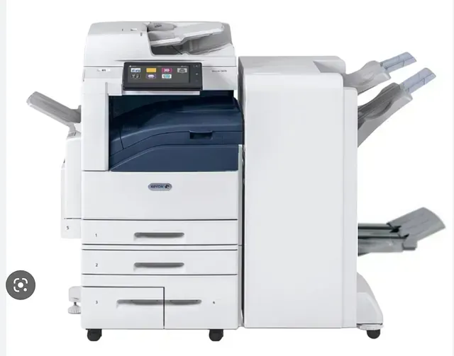 A white printer is sitting on top of a white table.