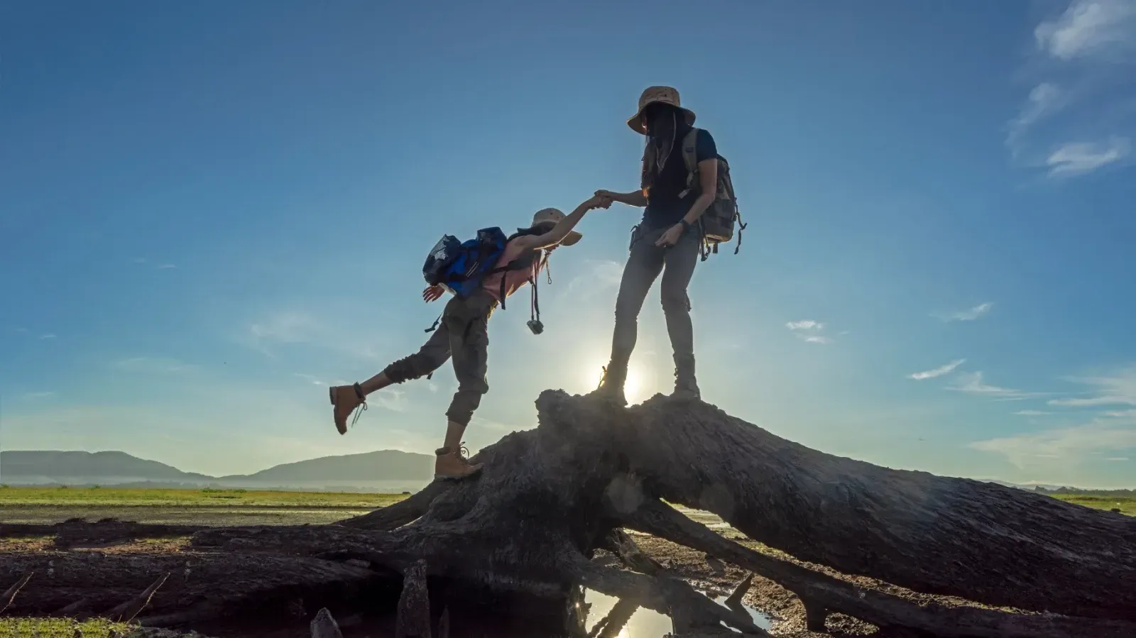 Dos personas agarrados de la mano en el monte.