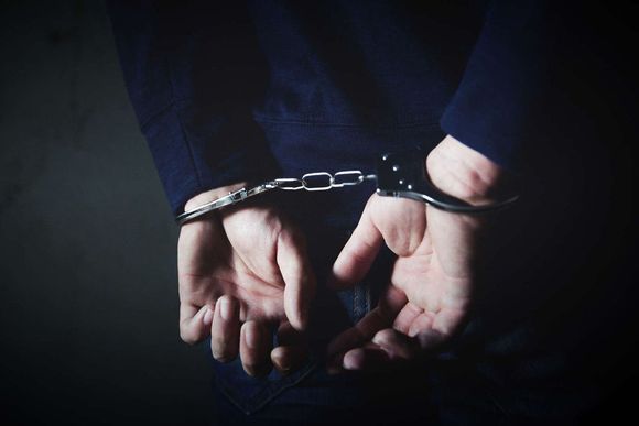 Handschellen - Festnahme Männliche Person ist mit Handschellen auf dem Rücken fixiert