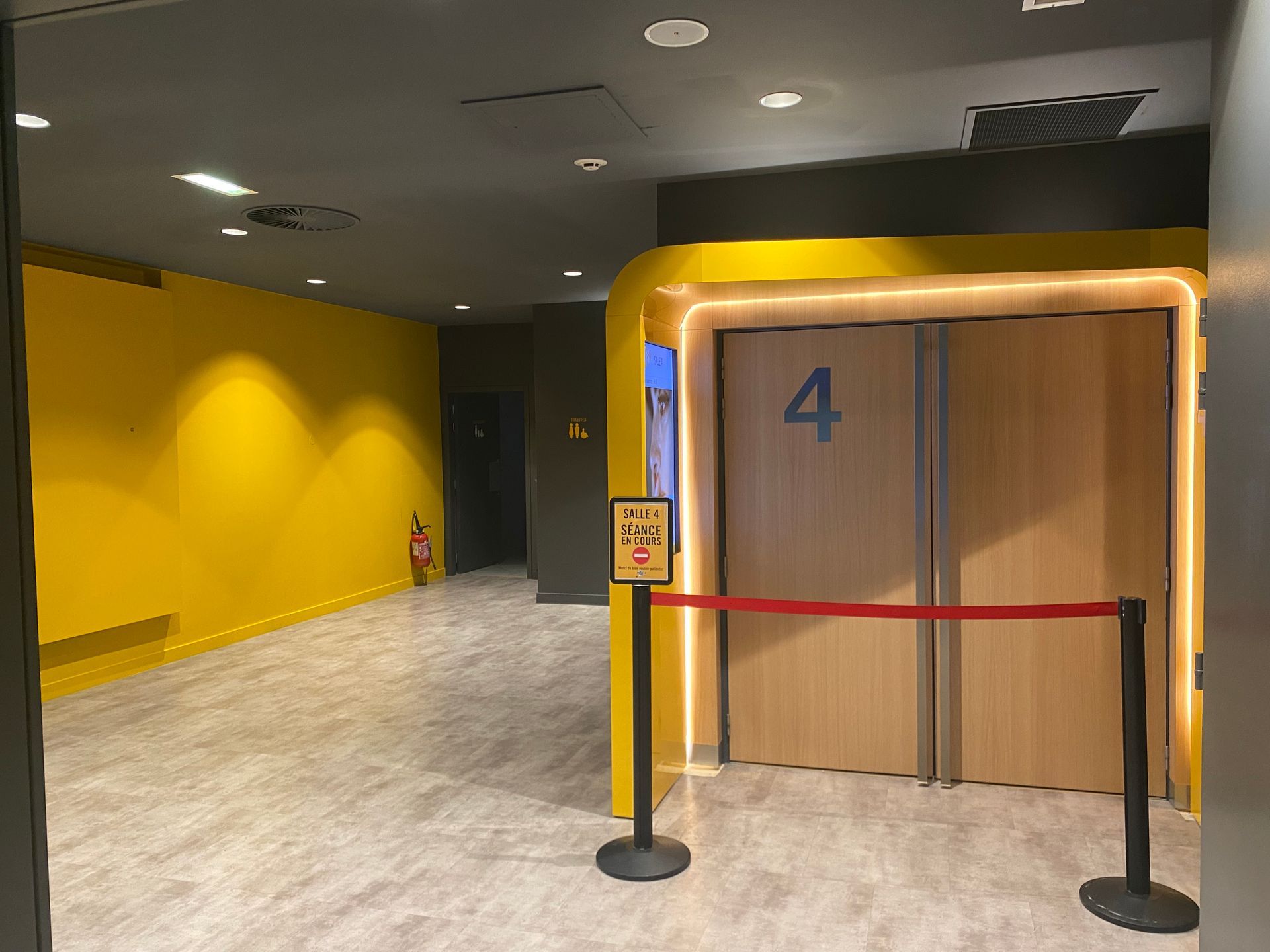 Peinture jaune dans un couloir desservant les salles de cinéma