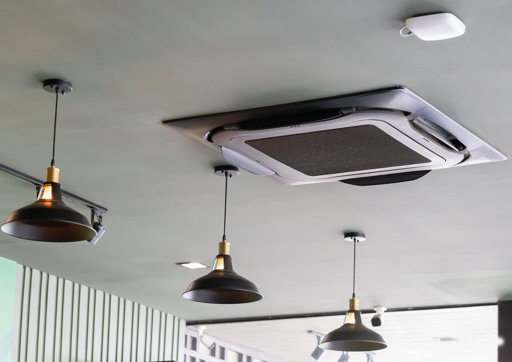 Un climatiseur cassette et des lampe de plafond