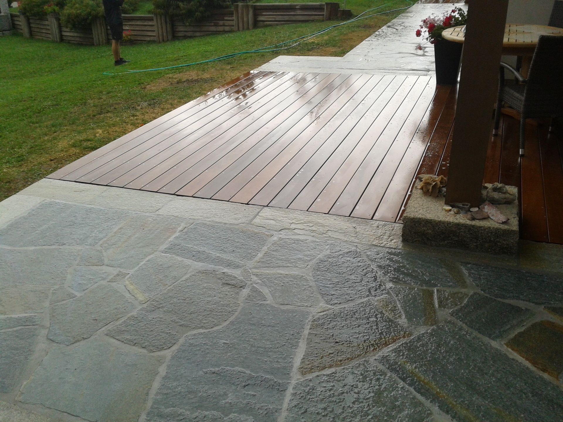 Une terrasse en pierre avec un plancher en bois