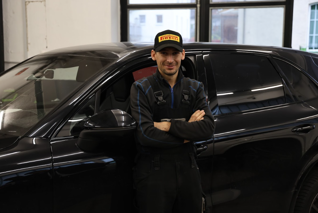 Innenansicht eines grünen BMW mit digitalem Armaturenbrett und Lenkrad.