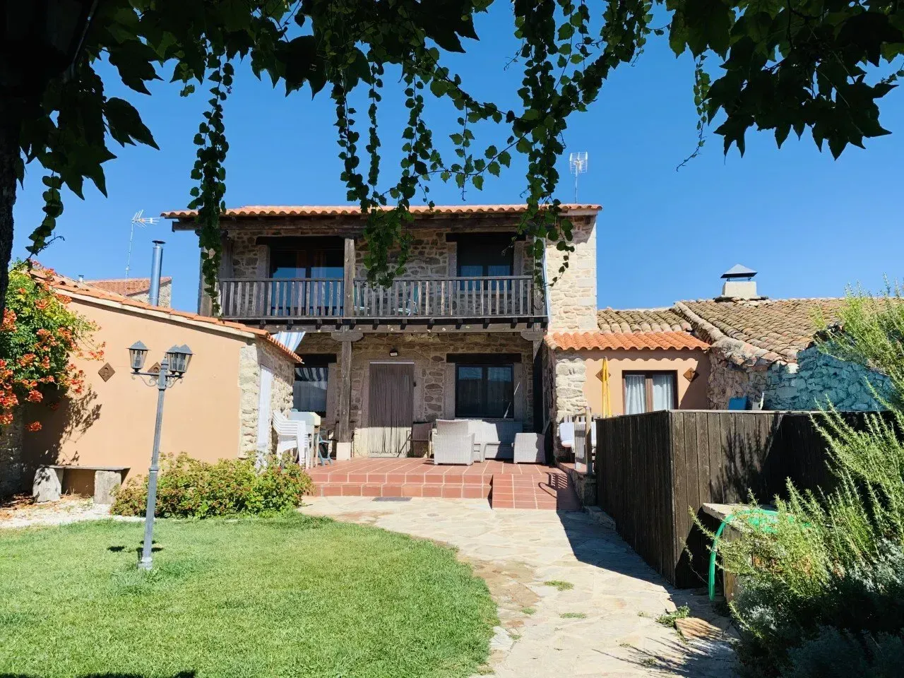 Una casa con un balcón y una valla delante.