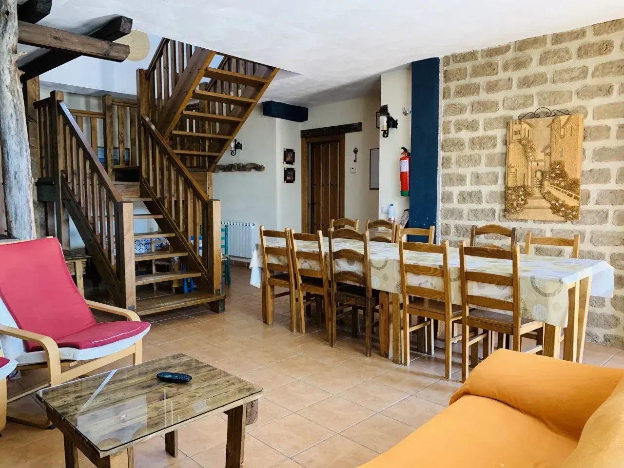 Una sala de estar con mesa y sillas y escaleras.