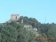 Un río que fluye a través de un campo de hierba con árboles al fondo.